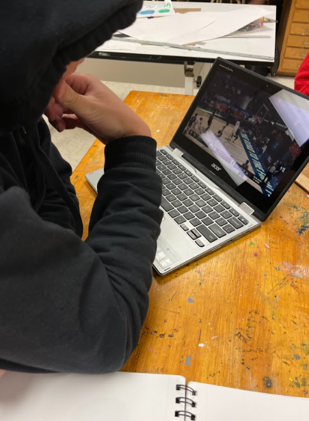 A Northwest student watches a game in class.